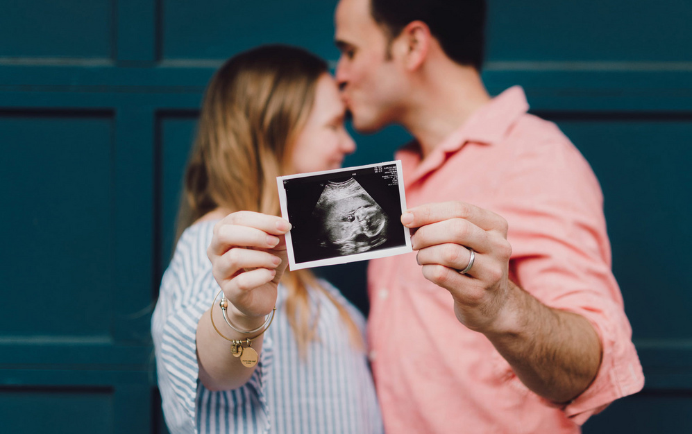 Couple holding ultrasound photo