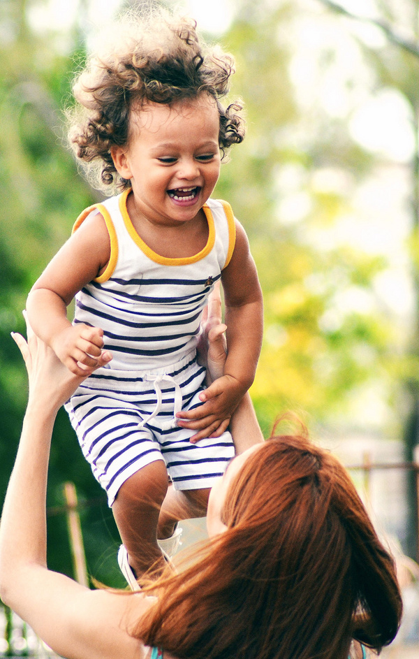 mother throwing toddler in the air 